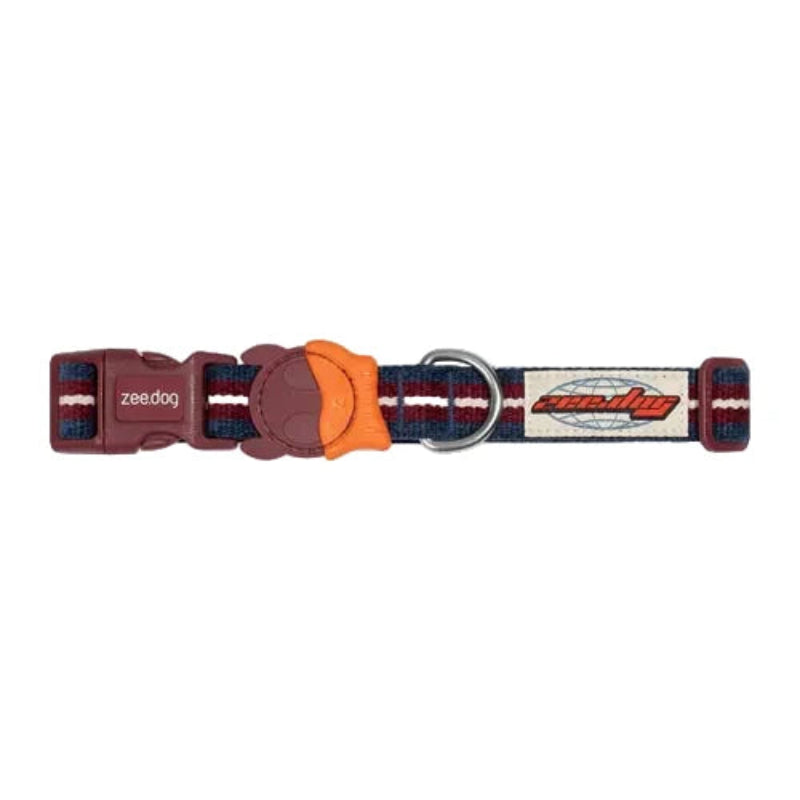 A Zeedog dog collar with a maroon plastic buckle, an orange paw-shaped plastic insert, and a woven strap featuring red, navy, and white stripes. The brand name 'zeedog' is visible on the buckle and the metal D-ring.