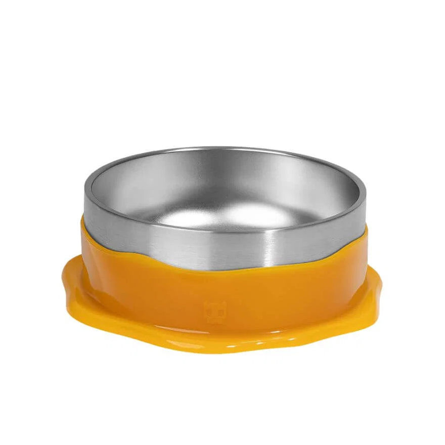 A stainless steel pet bowl with a bright orange silicone base that has a small yellow paw print in the center, set against a plain white background.